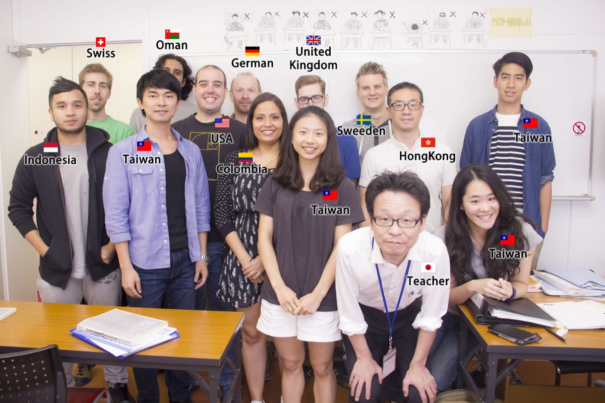 International group of students and teacher at Kudan, with flags showing home countries